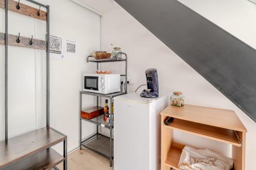eine Küche mit Kühlschrank und Mikrowelle in der Unterkunft Les mesliers in Sens-de-Bretagne