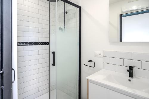ein Badezimmer mit Glasdusche und Waschbecken in der Unterkunft Les mesliers in Sens-de-Bretagne