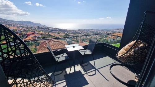 a balcony with a table and chairs and the ocean at Dream View in Funchal