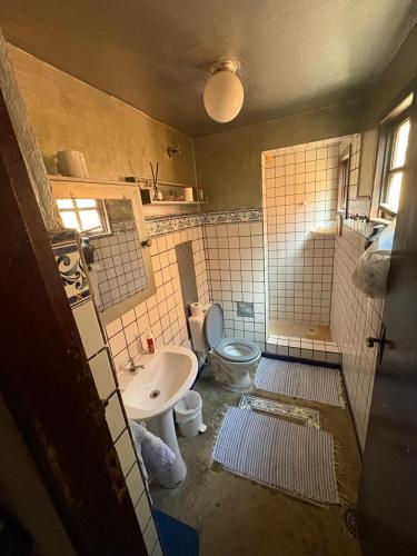 a bathroom with a toilet and a sink at Refúgio da Vila in Ilhabela