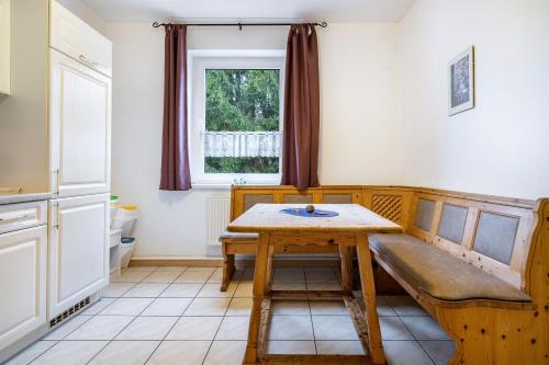 a kitchen with a table and a bench and a window at Kolbatzer Mühle in Lychen