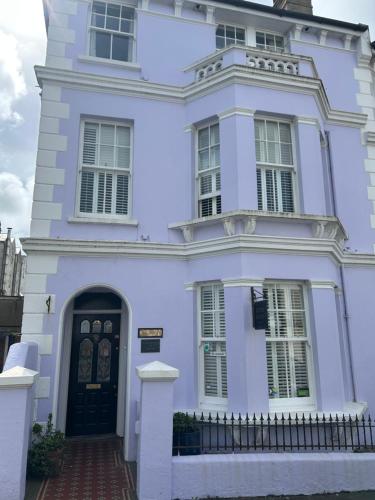 a white house with a black door at Gyves House in Eastbourne