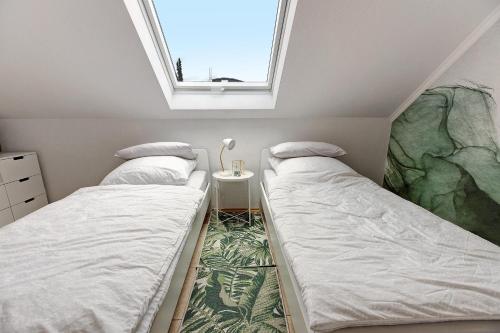 two beds in a small room with a window at Reif Markelfingen in Radolfzell am Bodensee