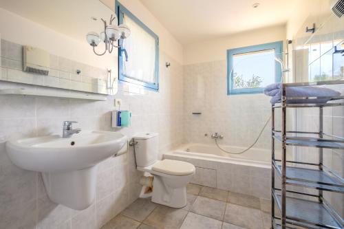 a bathroom with a sink and a toilet and a bath tub at Appartement Numéro 2 - piscine in Valbonne