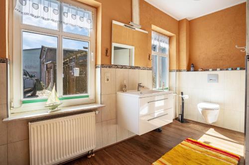 a bathroom with a sink and a toilet and a window at Ferienzimmer auf Der Insel Rügen in Sagard