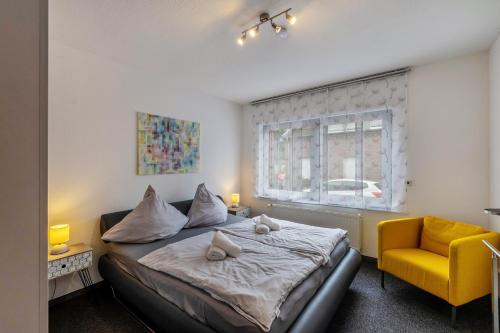 a bedroom with a bed and a yellow chair at Heike in Willich
