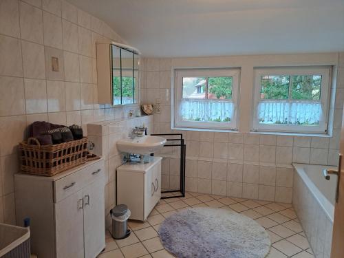a bathroom with a sink and a toilet and a tub at Les Papillons in Tennenbronn