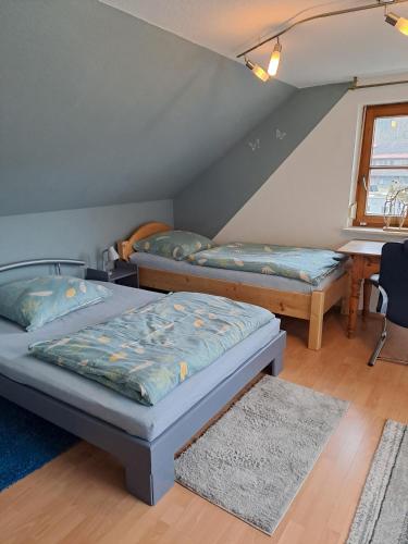 a room with two beds and a table at Les Papillons in Tennenbronn
