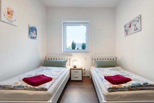 two twin beds in a room with a window at Speicherhäuschen Maike in Geeste