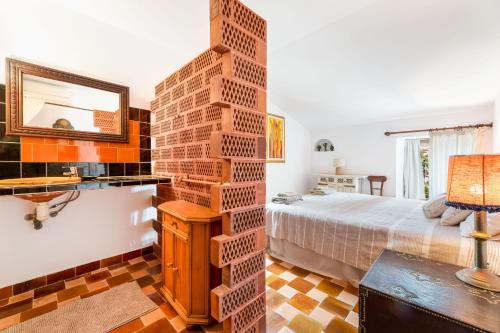 a bedroom with a brick wall next to a bed at El Palomar in Santanyi