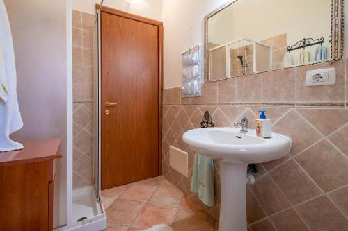 a bathroom with a sink and a mirror at Casa Michela in Viddalba