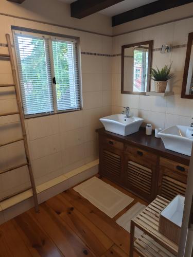 a bathroom with two sinks and two windows at Mas De Palaille, Piscine et Nature in Salvagnac-Cajarc