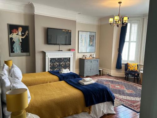 a bedroom with a bed and a tv on the wall at Gyves House in Eastbourne