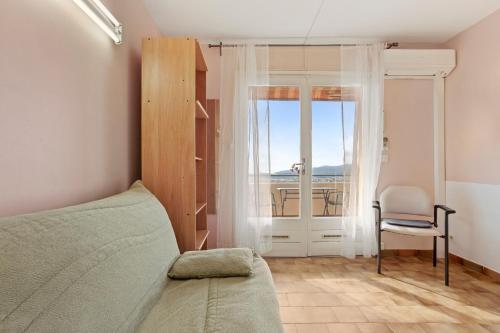 a bedroom with a bed and a chair and a window at Le Mas Berliat studio N° 10 in Bormes-les-Mimosas