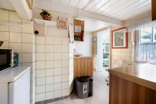 a kitchen with white tile walls and a counter at Ferienhaus Bruhn in Flensburg