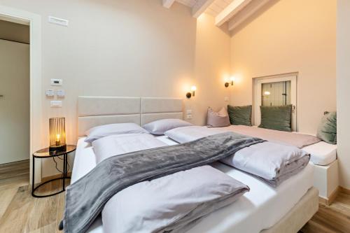 a bedroom with two beds with white sheets at Cavalino Boutique 2 in Cavaion Veronese