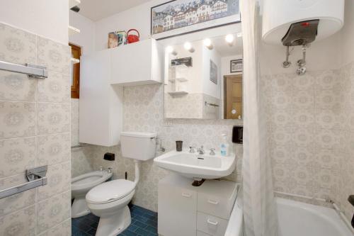a white bathroom with a toilet and a sink at Courmayeur 3V21 in Courmayeur