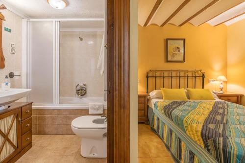a bedroom with a bed and a sink and a toilet at Albahaca in Hinojares