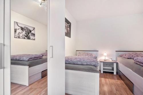 a small bedroom with two beds and a table at Zum Waldblick in Wulsbüttel