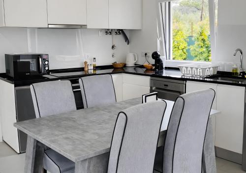a kitchen with a table with chairs and a microwave at Forest Village T2 in Mindel