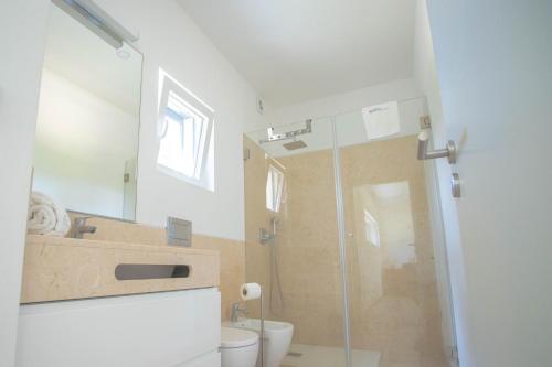 a bathroom with a shower and a toilet and a sink at Forest Village T2 in Mindel