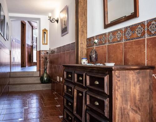 a room with a wooden dresser and a hallway at Casa Rural Los Enebros in Los Navalucillos