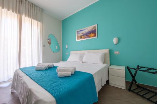 a blue bedroom with a bed with towels on it at Paladino in Giardini Naxos