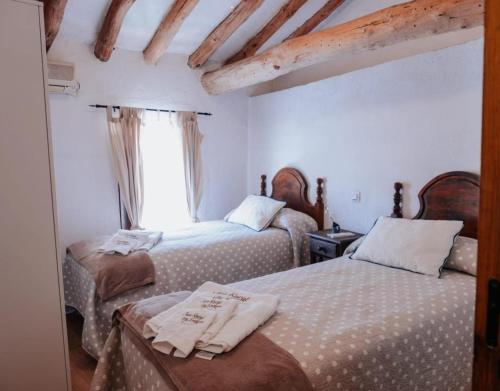a bedroom with two beds and a window at Casa Rural Los Enebros in Los Navalucillos