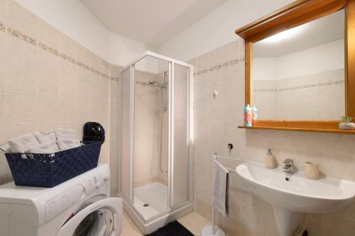 a bathroom with a washing machine and a sink at Plain Soleil ski home in Prato Nevoso