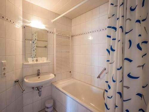 a white bathroom with a sink and a tub and a toilet at Ferienhof Dreher in Meersburg