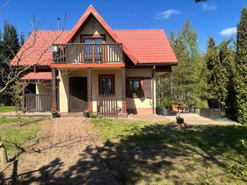a house with a red roof and a yard at Domek wakacyjny in Krzywólka
