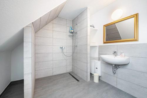 a white bathroom with a sink and a mirror at Ferienwohnung Dierking in Gilten