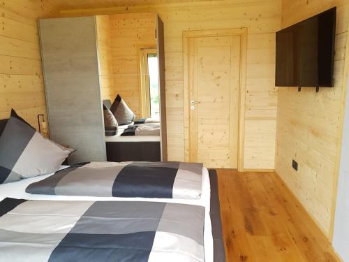 a bedroom with a bed and a flat screen tv at Ferienhaus Summerwiese in Ochsenhausen
