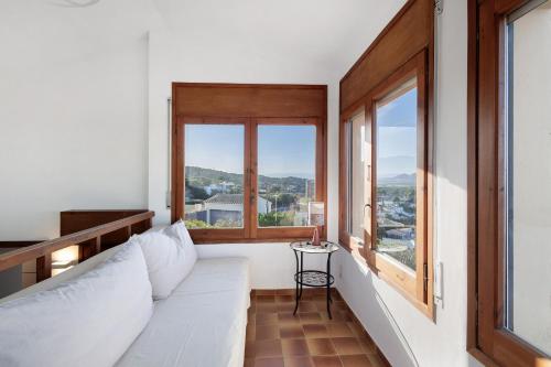 a room with a white couch and two windows at Racó 72 in Begur