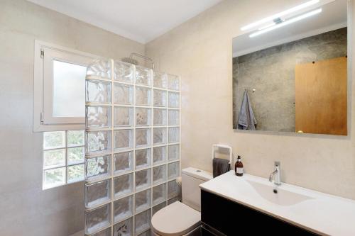 a bathroom with a sink and a toilet and a window at Racó 72 in Begur