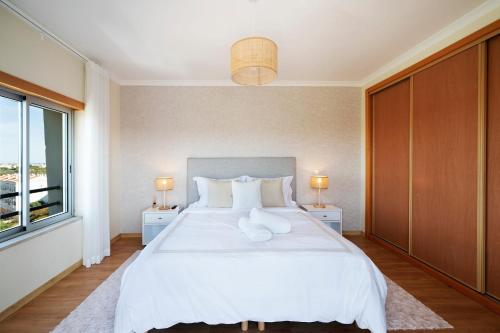 a bedroom with a large white bed and a window at Penthouse Monte da Eira - Sunset in Albufeira