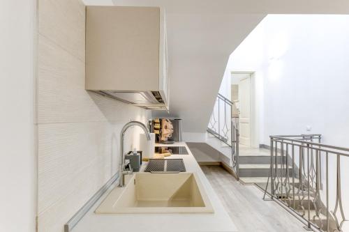 a kitchen with a sink and a staircase at Casa Don Paolo in Alessano