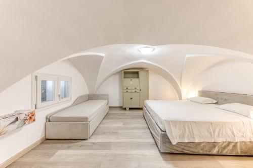 a bedroom with two beds and a white ceiling at Casa Don Paolo in Alessano
