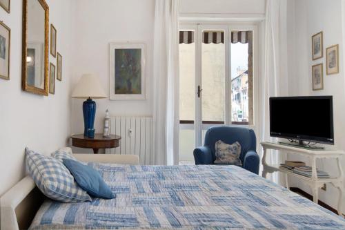 a bedroom with a bed and a tv and a chair at Zaffiro Apartment With Garage in Rapallo
