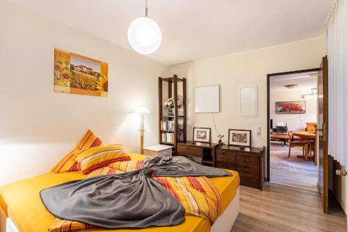 a bedroom with a yellow bed and a mirror at Ferienwohnung am Mozarthügel in Warstein