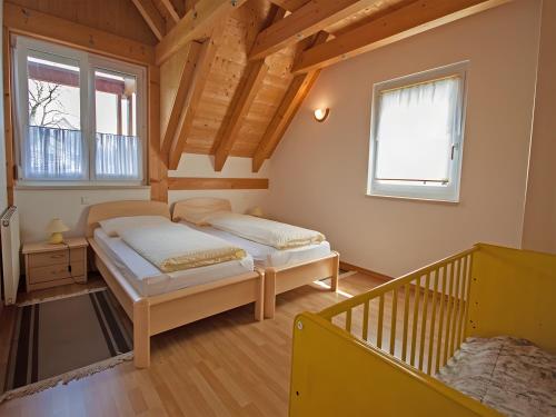 two beds in a room with a wooden ceiling at Ferienhof Dreher in Meersburg