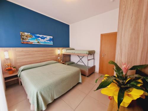 a bedroom with a bed and a plant in a room at Club Vacanze In in Cervia