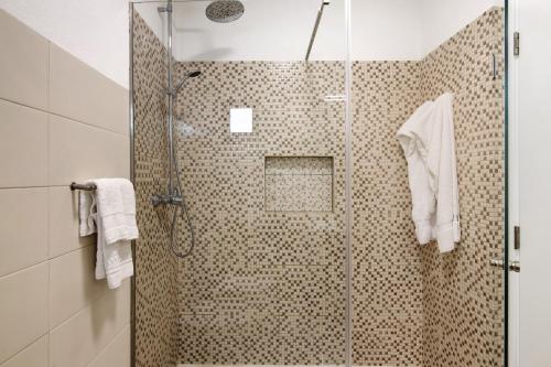 a bathroom with a shower with a glass door at Pear Tree Villa in Vale do Lobo
