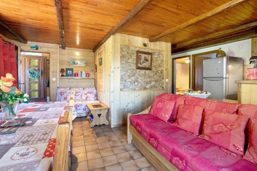 a living room with a red couch and a table at Chalet Lou Murgis in Saint-Sorlin-dʼArves