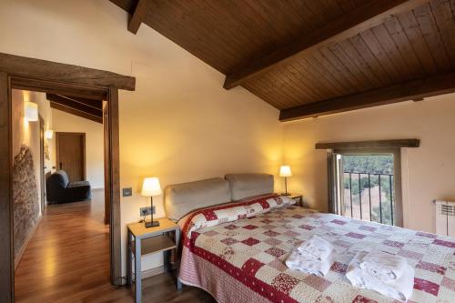 a bedroom with a bed and a table with two lamps at Torigues in Santa María de Oló