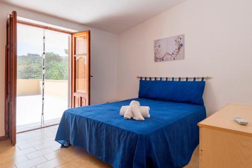 a bedroom with a blue bed with a towel on it at Casa Viola - a 100 metri dal mare in Trappeto