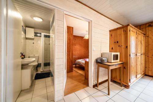 a small bathroom with a sink and a microwave at Chez les Charles in Bernex
