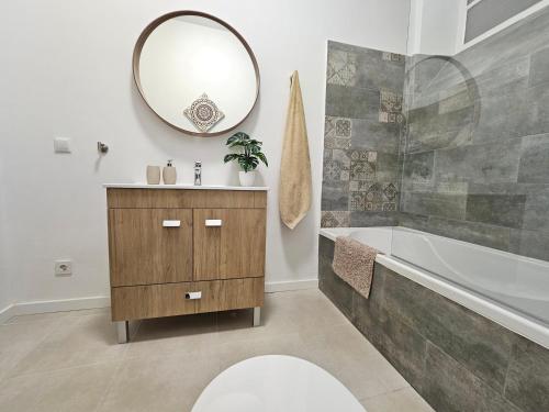 a bathroom with a sink and a tub and a mirror at Casa Semedo in Montemor-o-Novo