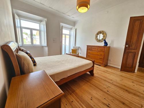 a bedroom with a bed and a table and a dresser at Casa Semedo in Montemor-o-Novo