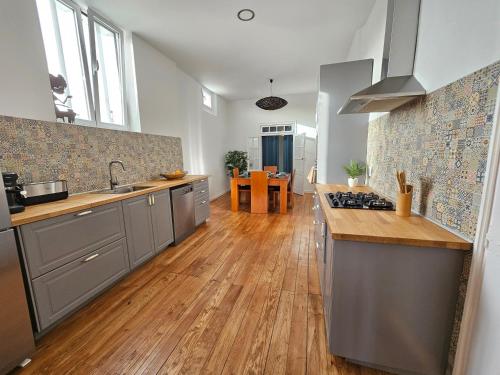 a kitchen with stainless steel appliances and wooden floors at Casa Semedo in Montemor-o-Novo